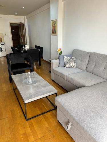 uma sala de estar com um sofá e uma mesa em Ithaki Phinikoudes Apartment No. 105 em Lárnaca