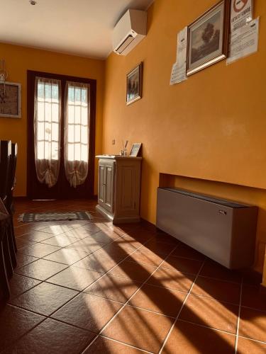 a room with yellow walls and a tiled floor at Residence Tenuta Gambalonga in Cinto Euganeo