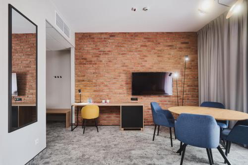 a room with a table and chairs and a tv at Halo Szczecin in Szczecin