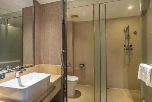 a bathroom with a sink and a shower at ALLIN HOTEL in Shenzhen