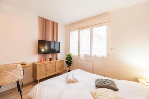 a bedroom with a bed and a tv on the wall at Studio l'escale Bretonne - Saint-Brieuc in Saint-Brieuc