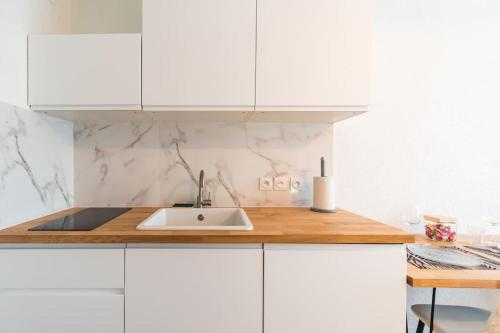 a kitchen with white cabinets and a sink at Studio l'escale Bretonne - Saint-Brieuc in Saint-Brieuc