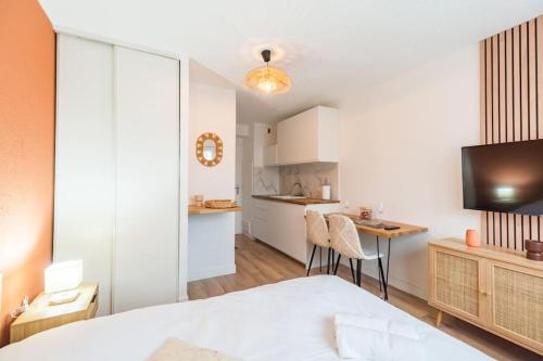 Cet appartement comprend une chambre avec un lit et une table ainsi qu'une cuisine. dans l'établissement Studio l'escale Bretonne - Saint-Brieuc, à Saint-Brieuc