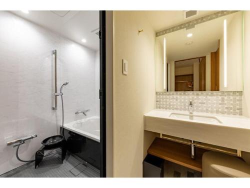 W łazience znajduje się umywalka i lustro. w obiekcie The OneFive Terrace Fukuoka - Vacation STAY 33419v w mieście Fukuoka