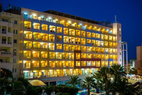 un gran edificio con luces encendidas por la noche en ALEGRIA Fenix Family en Roquetas de Mar