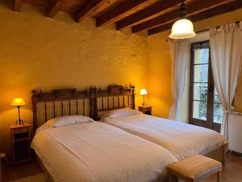 ein Schlafzimmer mit einem großen Bett und zwei Fenstern in der Unterkunft La casa del río in Alameda del Valle