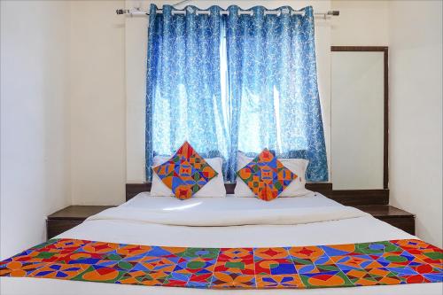 a bedroom with a large bed with a window at FabHotel Gokul Lodge in Pune