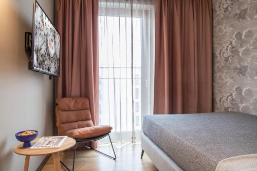 - une chambre avec un lit, une chaise et une fenêtre dans l'établissement ipartment Leverkusen, à Leverkusen