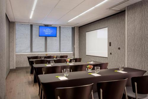 a conference room with tables and chairs and a screen at Fairfield Inn and Suites Chicago Downtown/ Magnificent Mile in Chicago