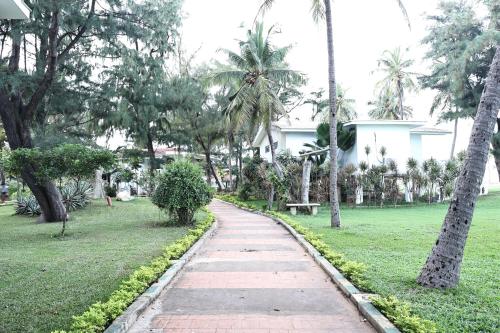 a walking path in a park with palm trees at Vgp Golden Beach Resort in Chennai