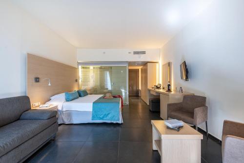 a hotel room with a bed and a couch at Atlantica Mikri Poli Kos in Kardamaina