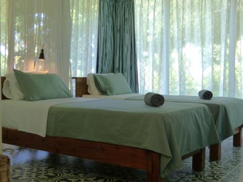 a bedroom with a bed and a window with curtains at Ancha's Oasis in Maputo