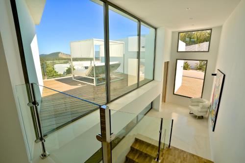 eine Glastreppe in einem Haus mit einem großen Fenster in der Unterkunft Villa Hava - Es Cubells in San Jose de sa Talaia