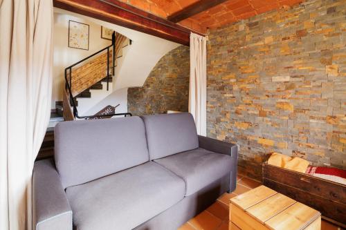 a living room with a couch and a brick wall at Masia d'en cot in Puigcerdà