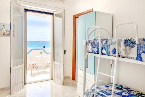 a bedroom with bunk beds and a view of the ocean at Casa Tridente - Meravigliosa villa sul mare in Torre Mozza