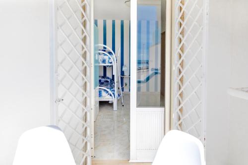 a hallway with a blue chair in a room at Casa Tridente - Meravigliosa villa sul mare in Torre Mozza