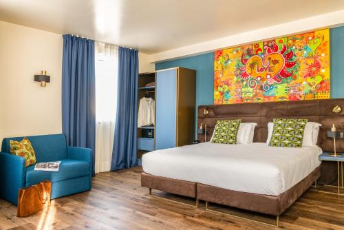 ein Schlafzimmer mit einem großen Bett und einem blauen Stuhl in der Unterkunft Hotel Rovereto in Rovereto