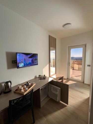 a room with a desk and a tv on the wall at B&B La Terrazza in Cotronei