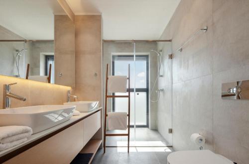 a bathroom with a sink and a toilet and a mirror at Nicosia Central Park Residences in Nicosia