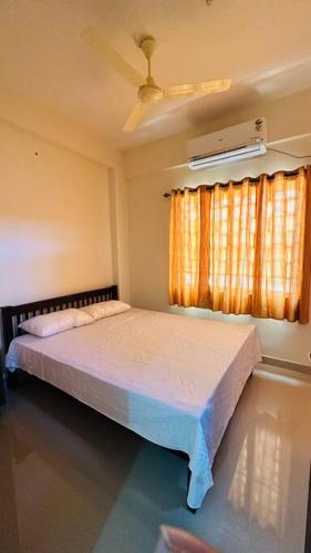 a bedroom with a bed and a ceiling fan at Peaceful Living Solo Suites in Ernakulam