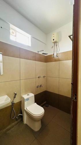 a bathroom with a toilet and a sink at Peaceful Living Solo Suites in Ernakulam