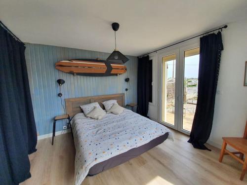 - une chambre avec un lit et une planche de surf sur le mur dans l'établissement Le clos Langella, à Léognan