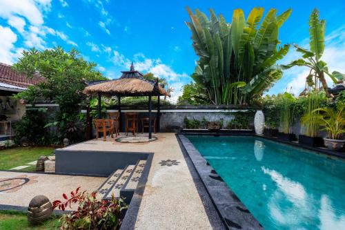 a swimming pool with a gazebo next to a house at Peaceful Tranquil Villa in Nusa Dua in Nusa Dua