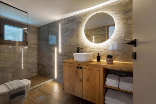 a bathroom with a sink and a mirror at Cosmopolitan luxury apartment by Smaris Collection in Hersonissos