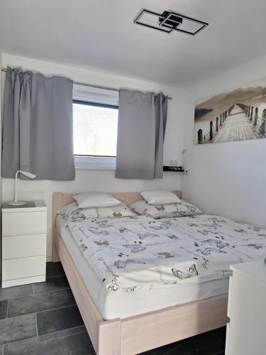 Schlafzimmer mit einem Bett und einem Fenster in der Unterkunft bungalov na břehu Labe s vlastním molem in Pardubice