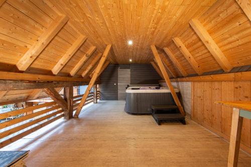 an attic room with wooden ceilings and a bed at Le Domaine du Verger gîtes et SPA in Osenbach