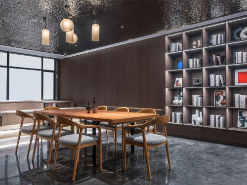 a dining room with a wooden table and chairs at Insail Hotels Guangzhou Beijing Road Pedestrian Branch in Guangzhou