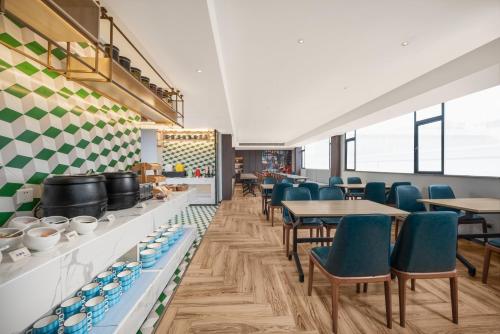 a restaurant with blue chairs and tables in a room at Insail Hotels Guangzhou Beijing Road Pedestrian Branch in Guangzhou
