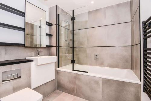 y baño con bañera, lavabo y aseo. en Luxury 2 Bedroom Apartment East London, en Londres