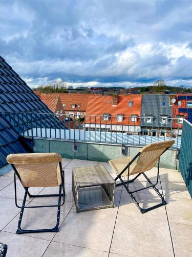 a pair of chairs sitting on top of a roof at Ahaus: Stadtoase mit Terrasse & privater Garage in Ahaus