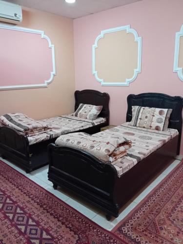 two beds in a room with a chalkboard at استراحة وزنه in Buraydah