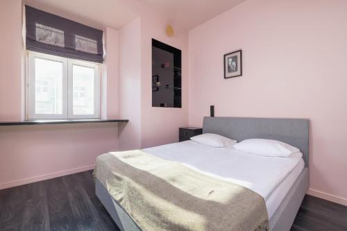 sypialnia z łóżkiem z białą pościelą i 2 oknami w obiekcie Apartment in Cracow Center with Air Conditioning, Desk and Balcony by Renters w Krakowie