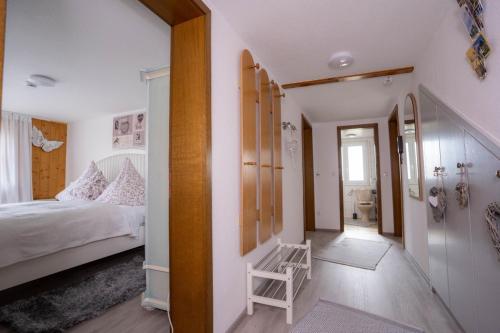 een slaapkamer met een bed en een stoel erin bij Ferienwohnungen KATI in Scheidegg