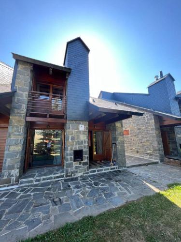 a stone house with a porch and a balcony at Chalet Los Ibones - Lodge Formigal in Formigal