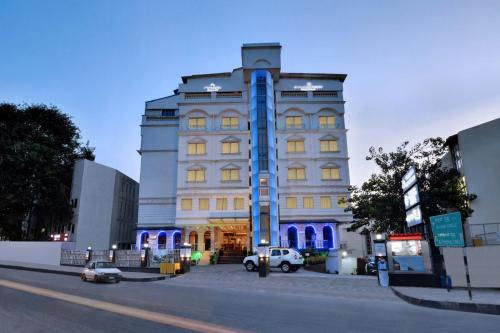 a large white building with blue lights on it at Hotel Ramanashree Richmond in Bangalore