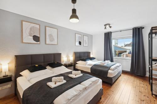 1 dormitorio con 2 camas y ventana en ANDRISS - Serviced Apartments I Workstations I WIFI en Kaiserslautern