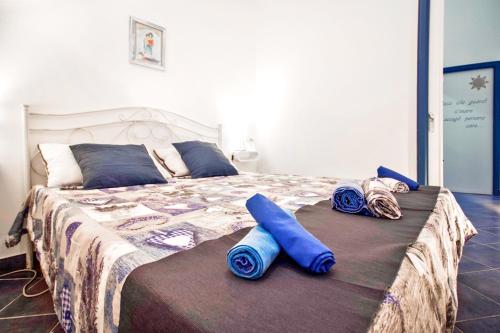 una camera da letto con un letto con cuscini blu di Casa di Giò - Confortevole casa sul mare a Torre San Giovanni Ugento