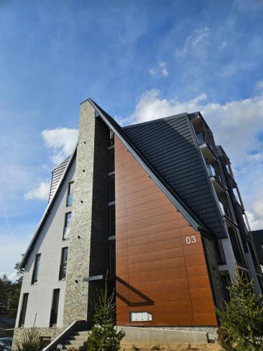 a building with a black and brown facade at Studio Apartman Nomad Divčibare in Divčibare