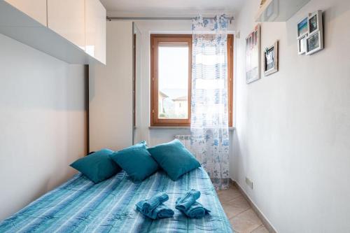 a bedroom with a bed with blue pillows and shoes at casa serena a Carmignano (Seano) vicino a Firenze in Seano