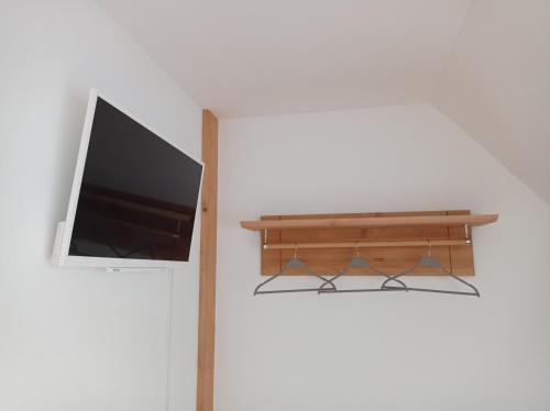 a flat screen tv hanging on a wall next to a door at Drei-Seiten-Hof Étable mit Schwimmteich und Klimanlage in Fuchshain