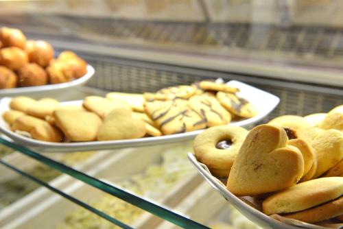 una vitrina con placas de donuts y otros productos de repostería en La Piccola Locanda, en Chiusi