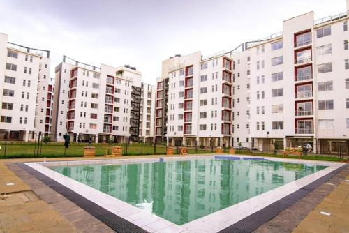 a large swimming pool in front of some buildings at Racecourse Garden in Nairobi
