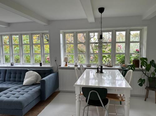 un soggiorno con divano blu e tavolo di Charmerende landsted med privat skov a Bjergby