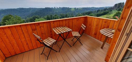 two chairs and a table on a wooden balcony at Lana Salta Alpakas - Gemütliche Ferienwohnungen auf dem Bauernhof in Murrhardt