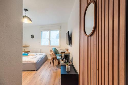 a bedroom with a bed and a desk and a mirror at Le studio briochin - Saint-Brieuc in Saint-Brieuc