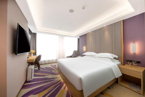 a bedroom with a large white bed and a desk at Guangzhou Baiyun Airport Yunzhi Hotel near Terminal One - Complimentary Shuttle Bus between hotel to Canton Fair Complex during Canton Fair in Guangzhou
